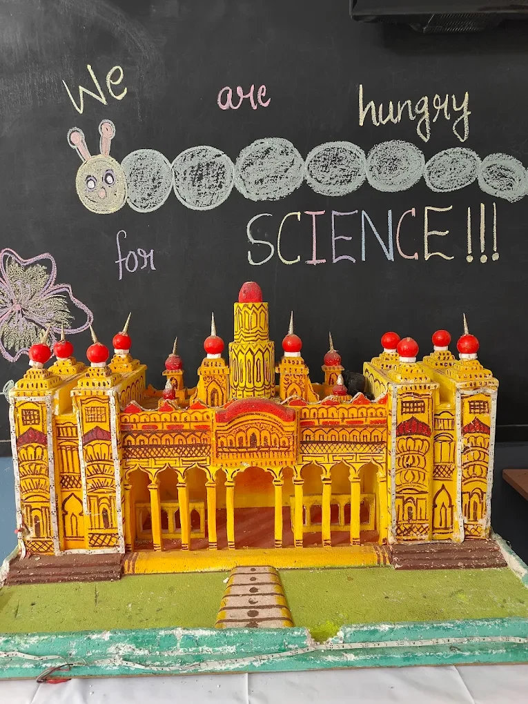 A student-made Mysore Palace model beneath a blackboard reading We are hungry for science