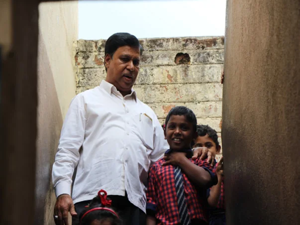 Founder Aijaz Ahmed with children in the school doorway