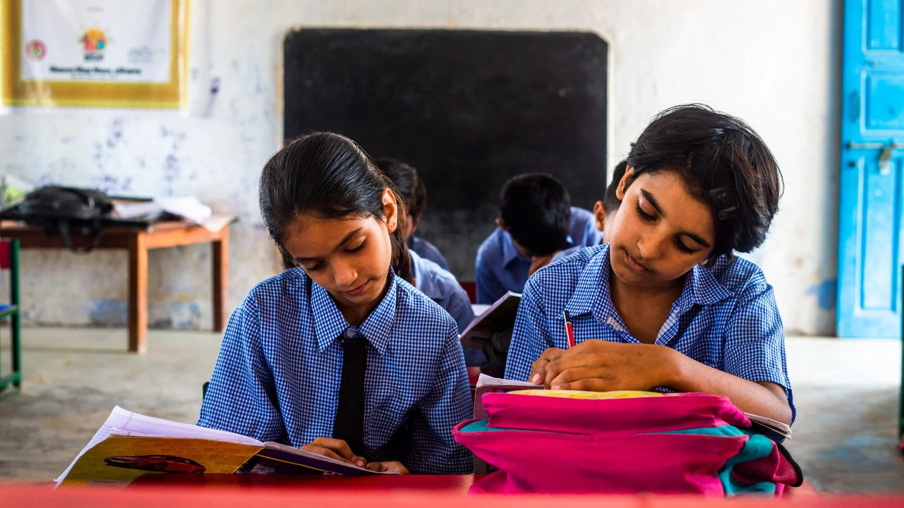Two Indian students studying together with books at a desk